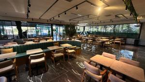 a restaurant with wooden tables and chairs and windows at Volonte Hotel & Spa in Bahçelievler