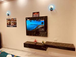 a flat screen tv hanging on a wall at Sukoon studios in Ghaziabad