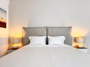 a bedroom with a large white bed with two lamps at Modern Spacious Mountain View Apt in Braşov