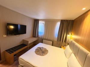 a hotel room with a bed and a flat screen tv at Volonte Hotel & Spa in Bahçelievler