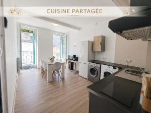 a kitchen and dining room with a table in a kitchen at Chambre Lumineuse avec Balcon - Cuisine Partagée & Salle de Bain Privée in Lourdes