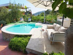 a swimming pool with a couch and an umbrella at Oasis Villa - Sea View Pool, Sanremo in Sanremo