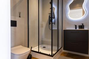 a bathroom with a toilet and a glass shower at Starowiejska Residence 1860 A in Miejsce Piastowe +5 photos