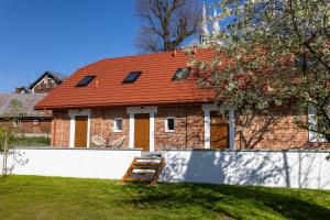 a brick house with an orange roof on a yard at Starowiejska Residence 1860 A in Miejsce Piastowe
