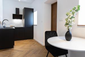 a kitchen and dining room with a white table and chairs at Starowiejska Residence 1860 A in Miejsce Piastowe
