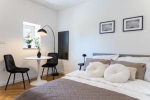 a bedroom with a bed with a table and chairs at Starowiejska Residence 1860 A in Miejsce Piastowe