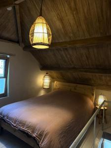 a bedroom with two lights and a bed in a room at L'Alterre Durbuy in Durbuy