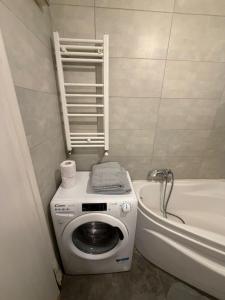 a bathroom with a washing machine next to a bath tub at RC RelaxApart 820 in Dudu +13 photos