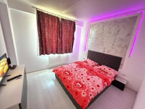 a bedroom with a red bed with pink lights at RC RelaxApart 820 in Dudu