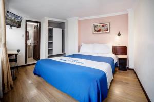 a blue and white bed in a hotel room at HOTEL AMERICANA PASTO in Pasto +5 photos