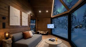a living room with a couch and a large window at Levi Nordic Star Igloos in Levi