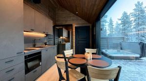 a kitchen with a table and chairs and a tub at Levi Nordic Star Igloos in Levi