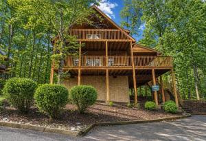 a cabin in the woods with a deck at Brentwood, Resort Pool, FREE Attraction tickets, Near Parkway, Hot Tub, Arcade Game, WIFI!!! in Pigeon Forge