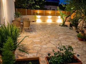 a patio at night with a table and chairs at Joannas Luxury Apartment in Corfu