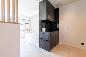 a kitchen with black cabinets and a sink in a room at Suite luxe jacuzzi - CANNES SUQUET in Cannes +6 photos