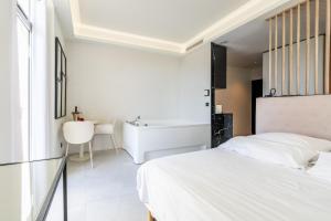 a bedroom with a white bed and a bath tub at Suite luxe jacuzzi - CANNES SUQUET in Cannes