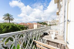 a balcony with a wooden bench on a white railing at Suite luxe jacuzzi - CANNES SUQUET in Cannes