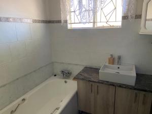 a bathroom with a bath tub and a sink at Highway Haven in Stilfontein