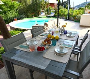 a table with breakfast food on it next to a pool at Oasis Villa - Sea View Pool, Sanremo in Sanremo