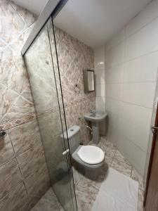 a bathroom with a toilet and a glass shower at Pousada Avenida MELHOR CUSTO-BENEFÍCIO in Teixeira de Freitas +24 photos
