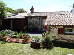 a small stone house with a garden in front of it at Studio de jardin dans son écrin de verdure in Saint-Lumine-de-Coutais