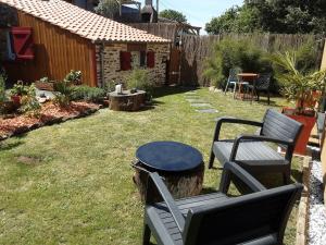 a patio with two chairs and a table in a yard at Studio de jardin dans son écrin de verdure in Saint-Lumine-de-Coutais