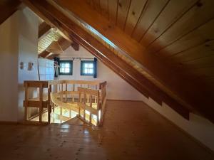 an attic room with a wooden table and chairs at Green river cottage in Žažina