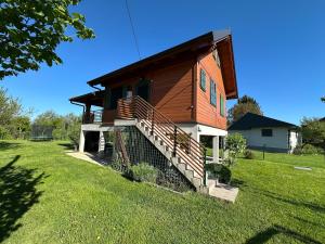 a small house with a staircase in a yard at Green river cottage in Žažina