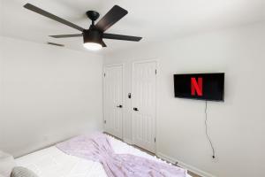 a bedroom with a ceiling fan and a sign on the wall at Pet Friendly Stylish Condo Near Campus in Gainesville +15 photos