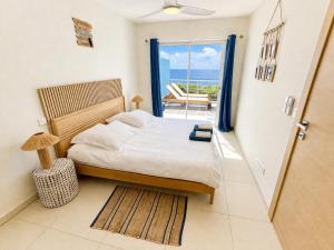 a bedroom with a bed and a view of the ocean at Villa Ar Mor - Oceanfront pool & Saint-Barth view Oyster pond in Saint Martin
