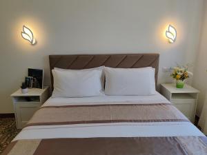 a bed with two white pillows and two night stands at Home Julia in Massa Lubrense