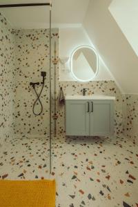 a bathroom with a shower with a sink and a mirror at Caesar Apartments & Rooms in Siófok +109 photos