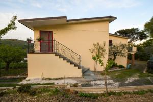 a small house with a red door and stairs at Casa La Pigna in Lucito