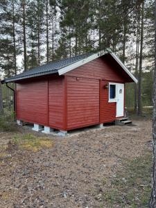 a red shed with a white door in the woods at Rena Hostel in Rena +16 photos