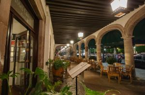 a restaurant with tables and chairs and a bench at Hotel Casino Morelia in Morelia