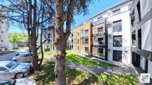 an apartment building with cars parked outside of it at Lepi Jova SNEZNIK in Vrnjačka Banja