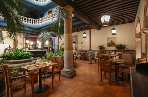 a restaurant with wooden tables and chairs and a lobby at Hotel Casino Morelia in Morelia