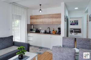 a living room with a couch and a kitchen at Lepi Jova SNEZNIK in Vrnjačka Banja +22 photos