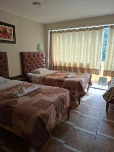 a bedroom with two beds and a window at Hotel las vegas in Huánuco +5 photos