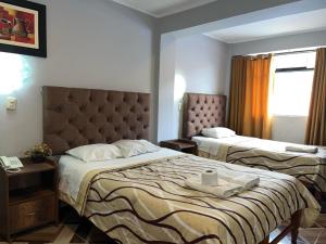 a hotel room with two beds and a window at Hotel las vegas in Huánuco