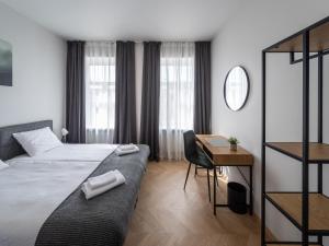 a bedroom with a bed and a desk with a table at M6 Rooms Riga in Riga