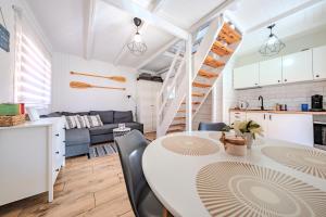 a kitchen and living room with a table and chairs at Nowoczesny domek z klimatyzacją i tarasem, blisko plaży Stegna House in Stegna