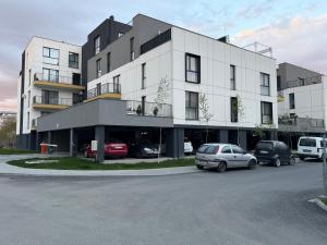a large white building with cars parked in a parking lot at IDDA Concept 2 dormitoare 2 și living in Târgu-Mureş