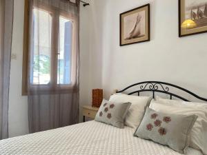 a bedroom with a white bed with pillows and a window at Ravanos Apartment in Loutraki