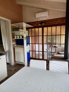 a room with two chairs and a kitchen with windows at Agriturismo Tenuta Blueberry - Glicine in Varallo Pombia