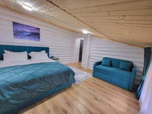 a bedroom with a bed and a blue couch at Отель MONBLAN in Yablunytsya