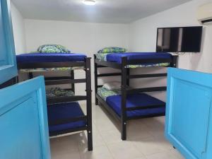 a room with three bunk beds and a tv at CASA FLOR DE LIZ in Villavieja