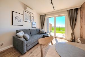 a living room with a couch and a glass door at Stegnova domki w Stegnie in Stegna