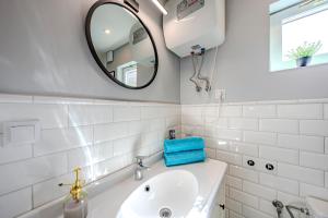 a white bathroom with a sink and a mirror at Nowoczesny domek z klimatyzacją i tarasem, blisko plaży Stegna House in Stegna +28 photos