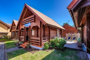 a log home with a deck and yard at Nowoczesny domek z klimatyzacją i tarasem, blisko plaży Stegna House in Stegna